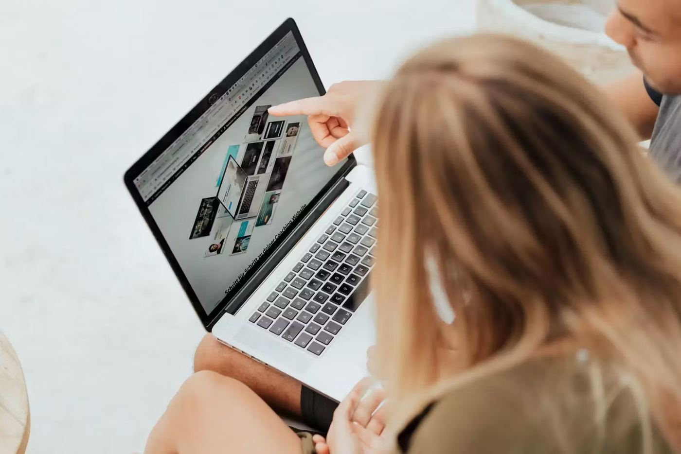 Zwei Menschen schauen gemeinsam auf eine Coaching-Website am Laptop